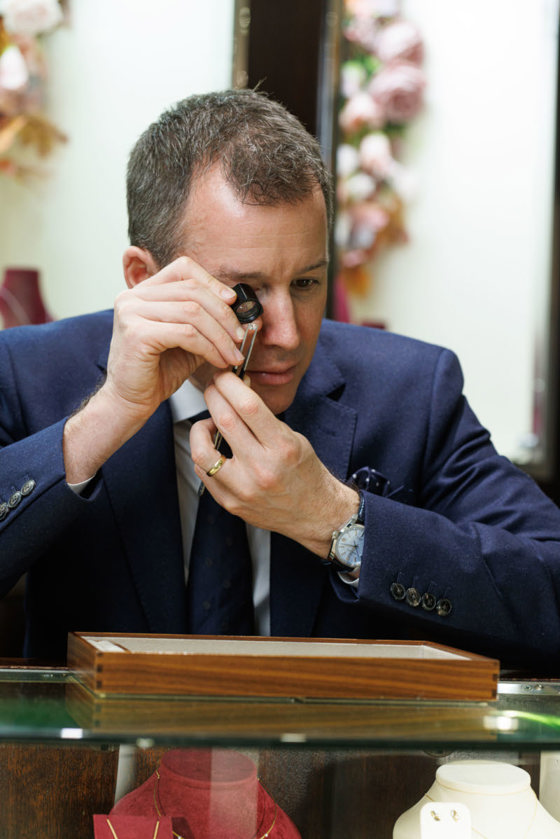 Simon Porter, fifth generation director of James Porter & Son, inspects jewels using an eyeglass